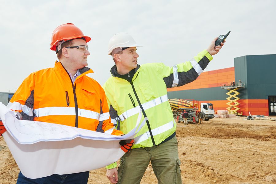 Zwei Bauleiter mit Bauplan auf der Baustelle